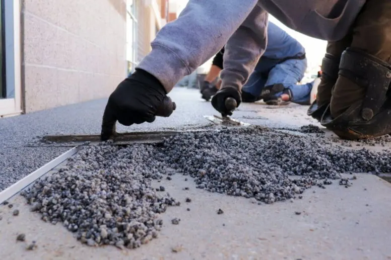 Local installers troweling a resin bound stone surface