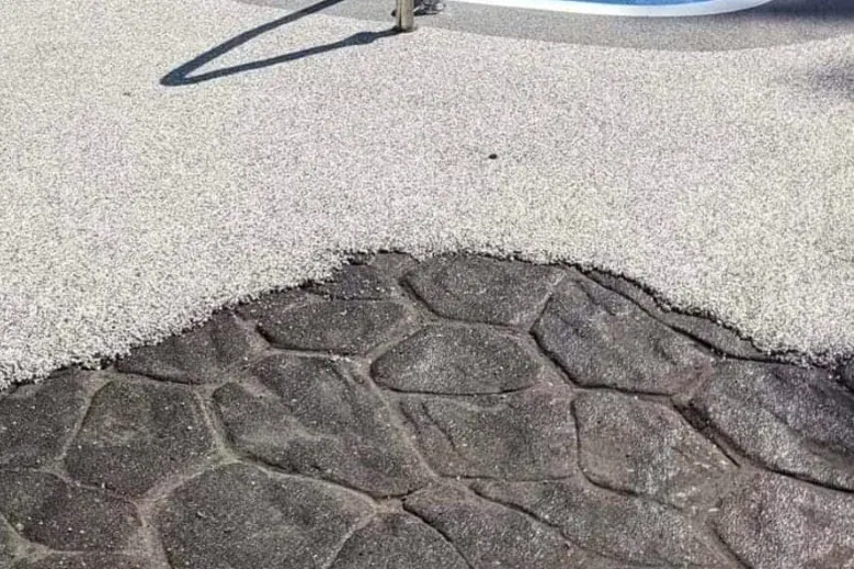 Resin bound stone overlay being trowelled over existing stamped concrete